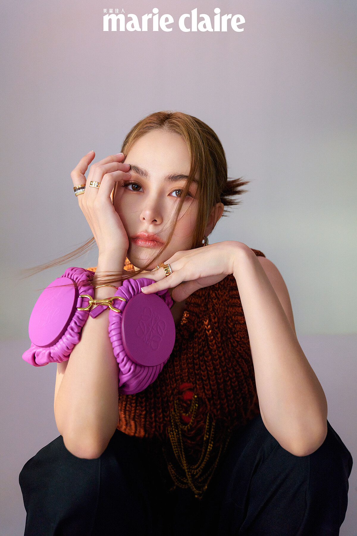 橘色針織背心、橘色背心、黑色寬版長褲、紫色手拿包，all by Loewe；Boucheron Quatre 系列耳環、Boucheron Quatre 系列手環、Boucheron Quatre 系列戒指，all by Boucheron。