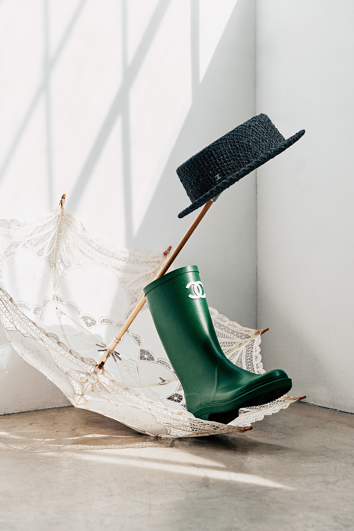 黑色斜紋軟呢紳士帽、綠色長靴，both by CHANEL。