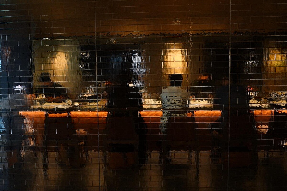 空間中手工訂製的⽔波磚紋玻璃透出隱約的光影相當迷人。