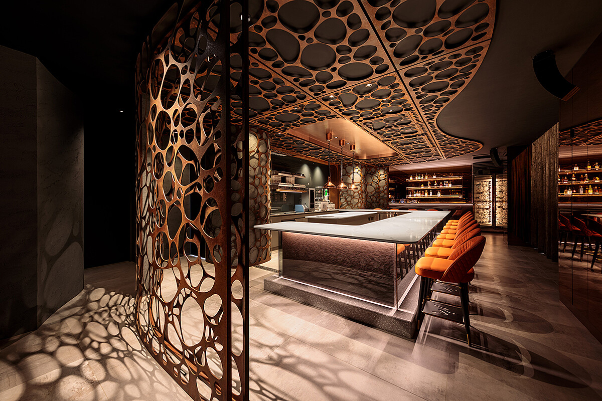 空間以岩石孔洞意象貫穿全場,使用金屬鏽蝕鐵板,質地透出沈沈的礦橘色,呈現洞穴般幽暗隱密感。