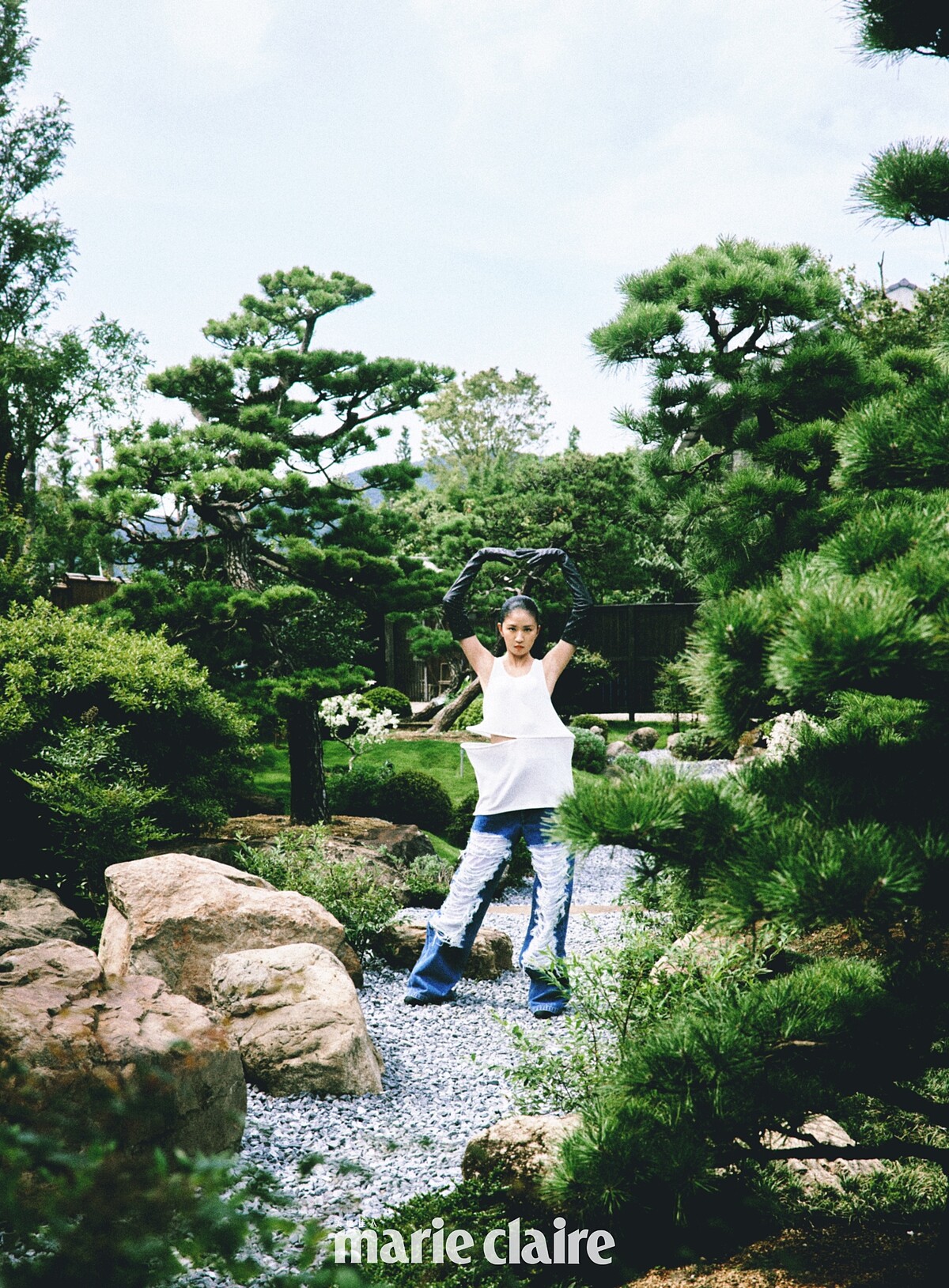 白色腰間鏤空立體剪裁背心、抓破設計牛仔褲，both by Loewe；鑽飾長手套、瑪莉珍高跟鞋，both by Chanel。