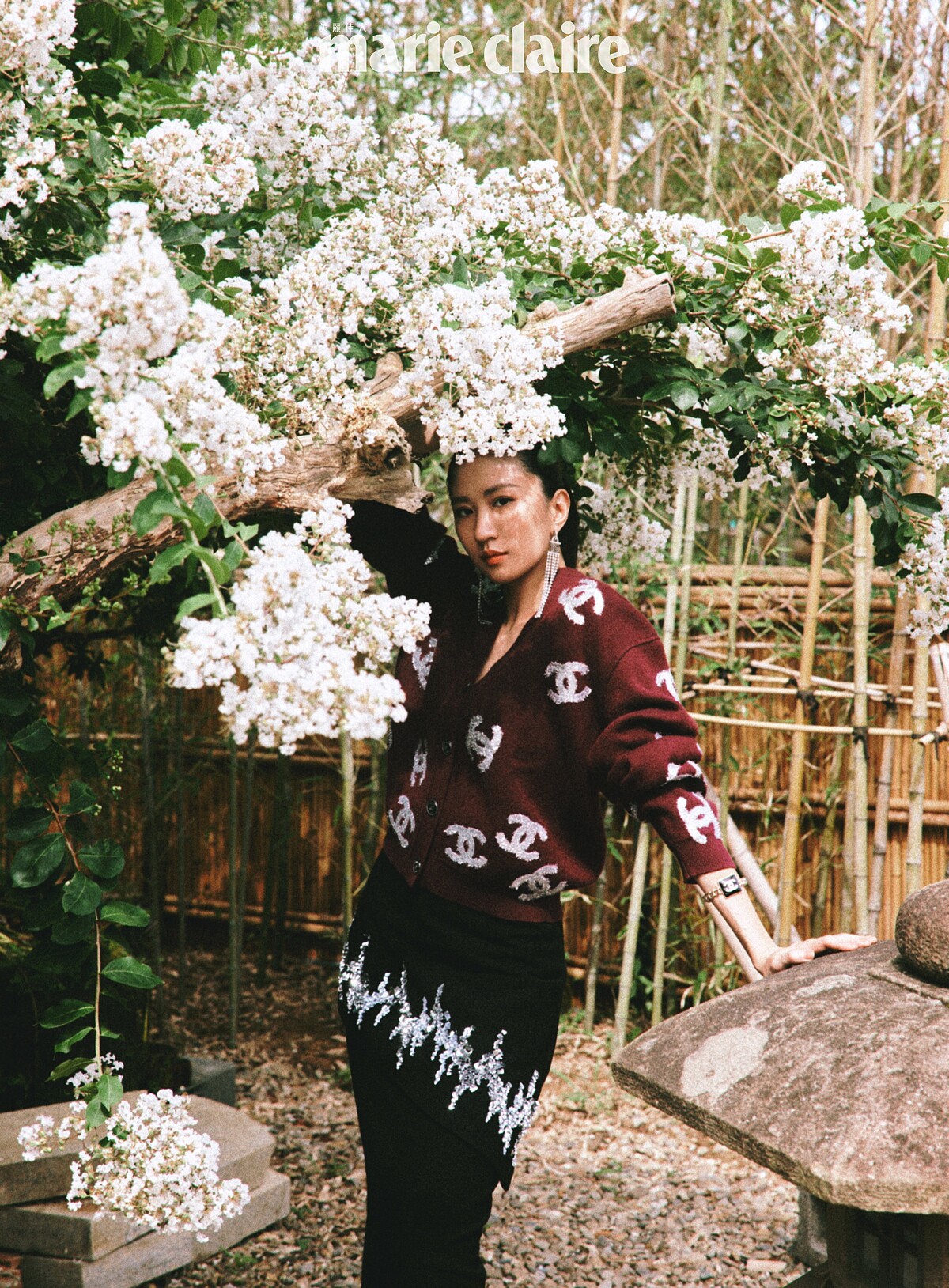 酒紅色刺繡圖紋針織衫、黑色長裙、長耳環、手環，all by Chanel。