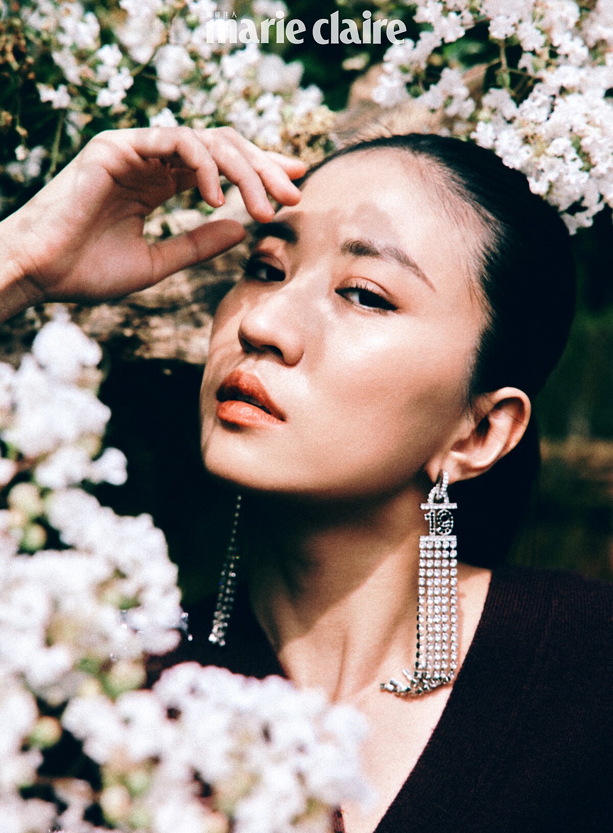 酒紅色刺繡圖紋針織衫、長耳環，both by Chanel。