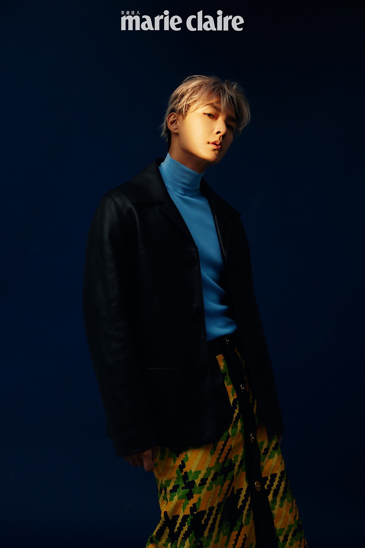 藍色針織高領毛衣，Prada；黃色格紋印花裙，Coach；黑色皮革外套，Sandro。