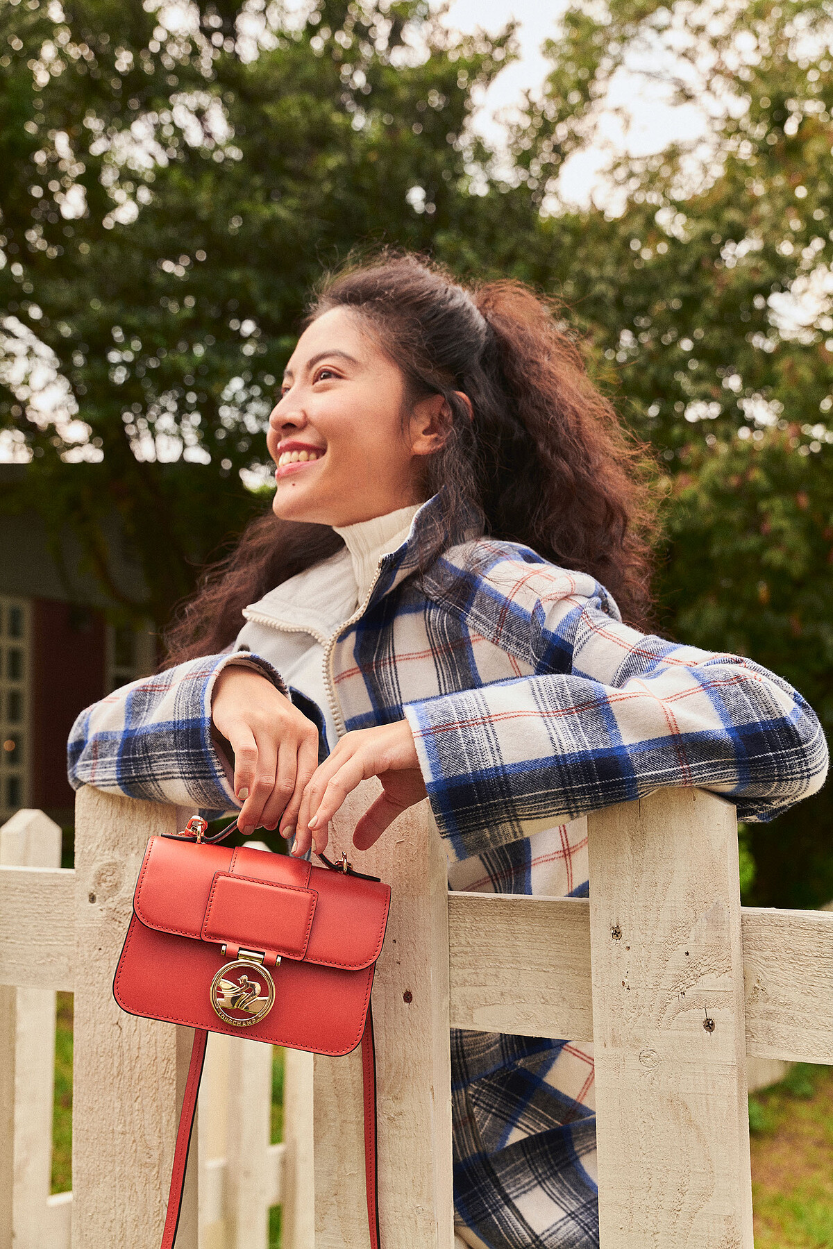 余惟：白色高領壓紋毛衣、藍白色格紋大衣、白色雨靴、橙色Box-Trot包款。