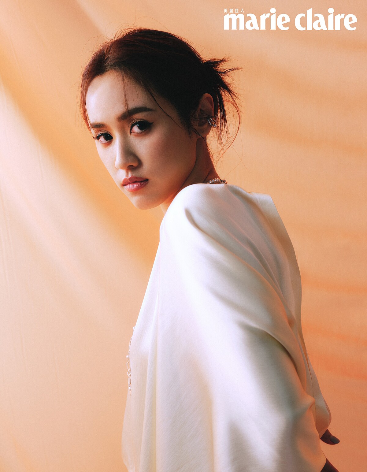 白色洋裝，Salvatore Ferragamo；珍珠項鍊、珍珠耳骨夾；both by Mikimoto。