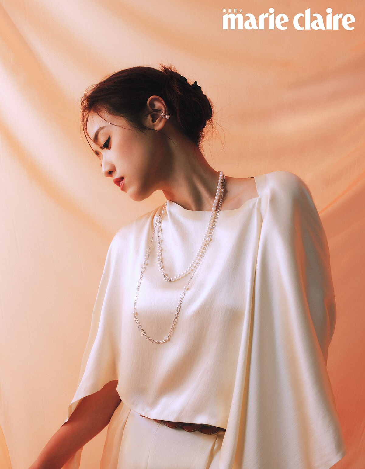 白色洋裝，Salvatore Ferragamo；珍珠項鍊、珍珠耳骨夾；both by Mikimoto。