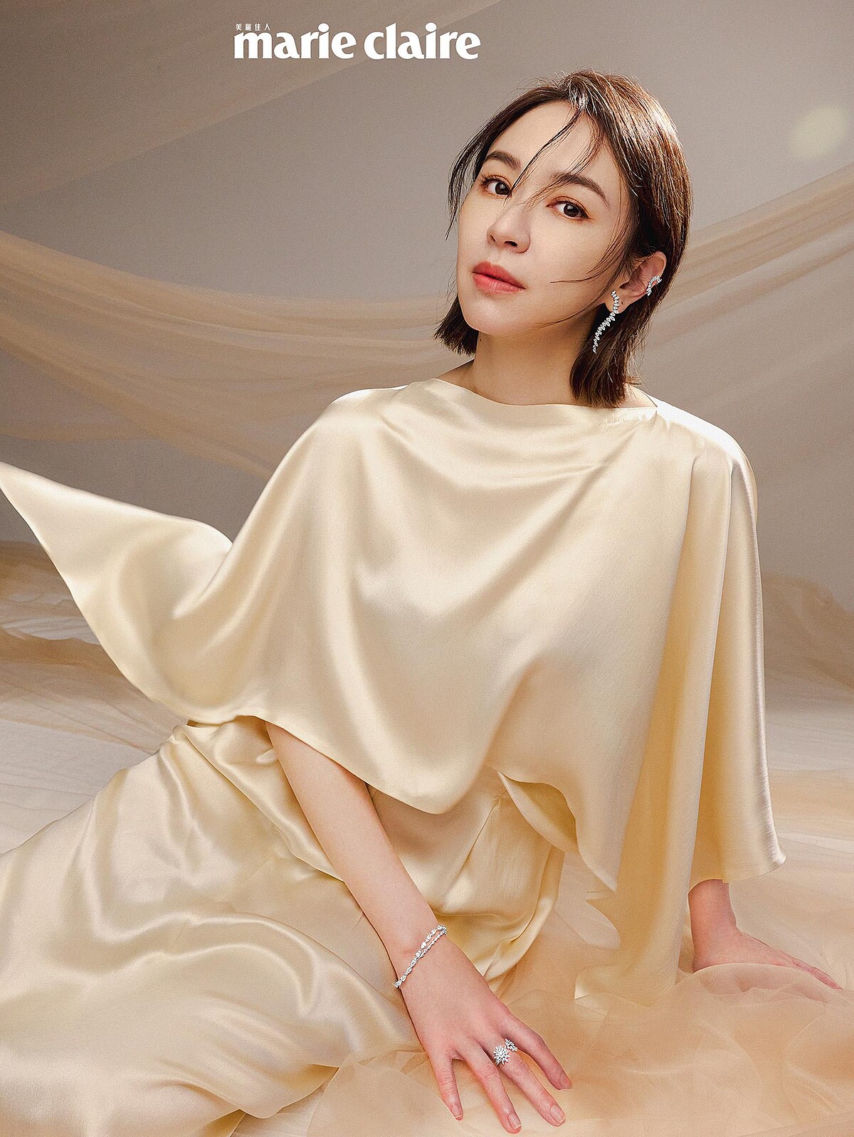 米白披肩長裙，Salvatore Ferragamo；Aerial Sunburst鑽石耳夾、Aerial Twisted Dewdrop鑽石耳環、Aerial Double Sunburst白K金鑽石戒指、Aerial Dewdrop白K金鑽石手鍊，All by Hearts On Fire。