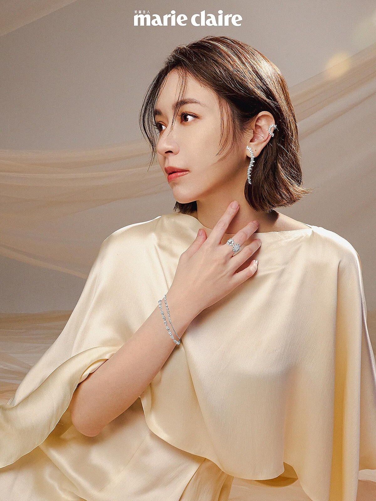米白披肩長裙，Salvatore Ferragamo；Aerial Sunburst鑽石耳夾、Aerial Twisted Dewdrop鑽石耳環、Aerial Double Sunburst白K金鑽石戒指、Aerial Dewdrop白K金鑽石手鍊，All by Hearts On Fire。