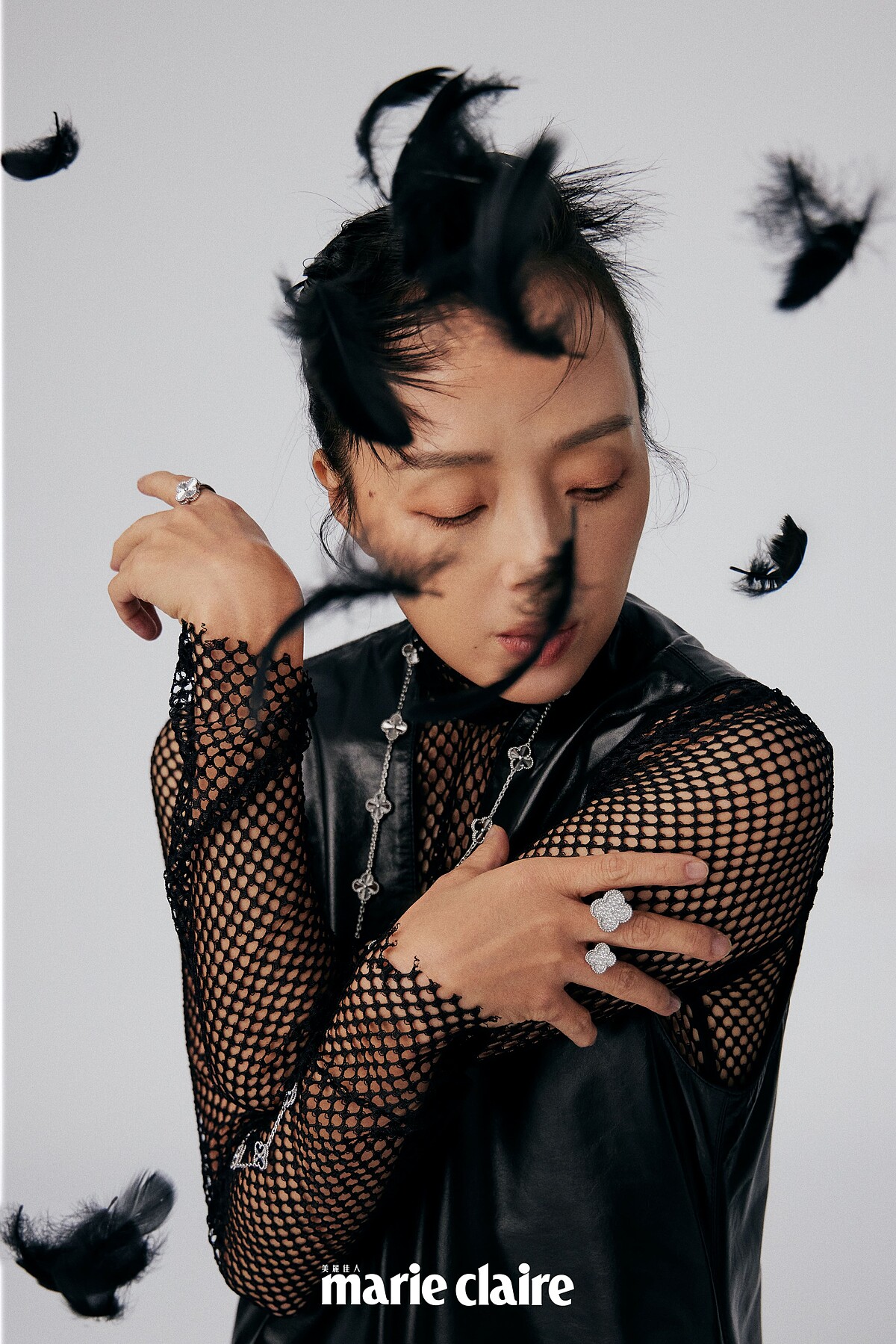 黑色V領皮革洋裝、黑色網狀上衣，JAMEI CHEN。 Vintage Alhambra 白K金璣鏤雕花20枚四葉幸運草圖騰長項鍊，Vintage Alhambra 白K金璣鏤雕花戒指，Magic Alhambra 白K金鑽石指間戒，all by Van Cleef & Arpels。