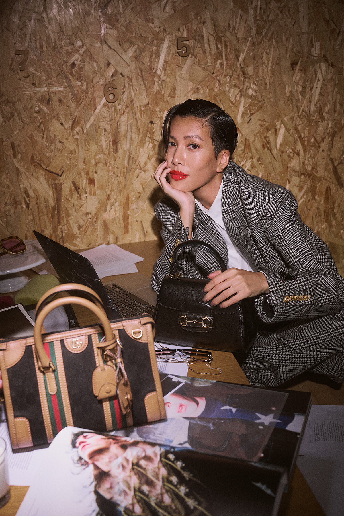 灰色西裝外套、白色襯衫、灰色西裝褲、黑色馬銜鍊皮鞋、黑色馬銜鍊手提包、黑色GG緹花波士頓肩背提包;all by Gucci。