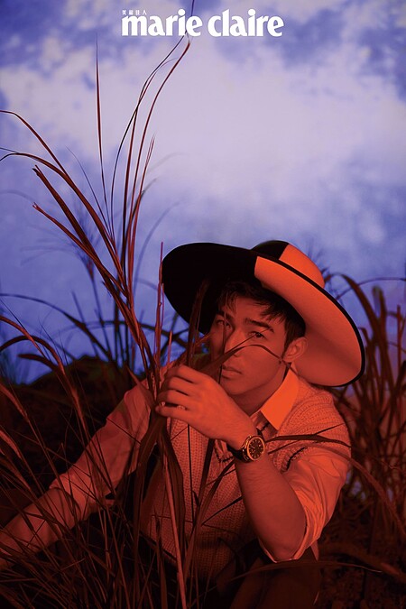 白色襯衫，Dior；米白色針織背心，Prada；咖啡色長褲，Valentino；黑白雙色寬沿帽，Gucci；Polo系列18K玫瑰金孔雀綠日期顯示腕錶，Piaget。