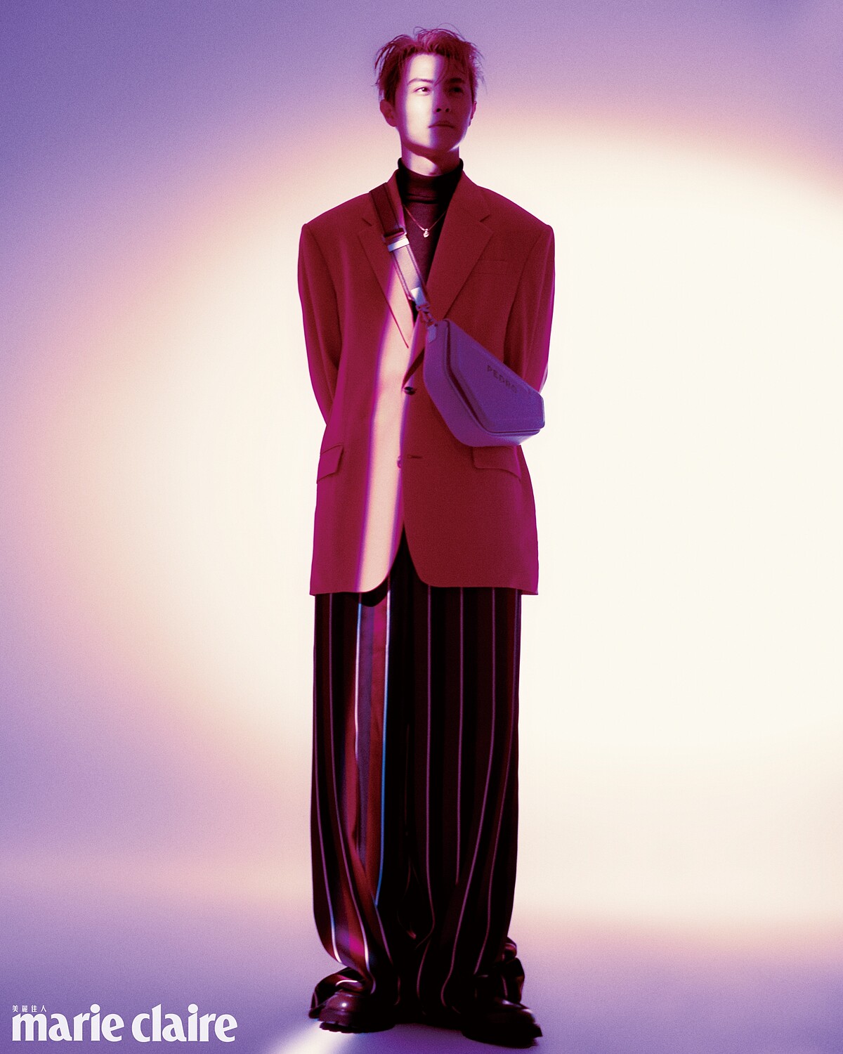 粉色西裝外套、紅色條紋寬鬆長褲、金色項鍊，all by Versace；酒紅色高領針織衫，John Varvatos；白色側背包、深綠色樂福鞋，both by PEDRO