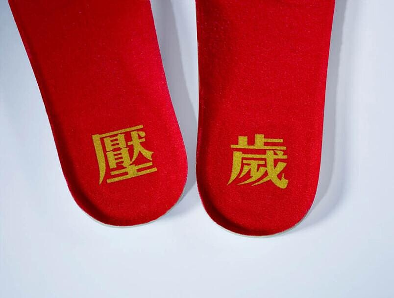 左右鞋墊上分別印有金色的「壓」和「歲」字樣