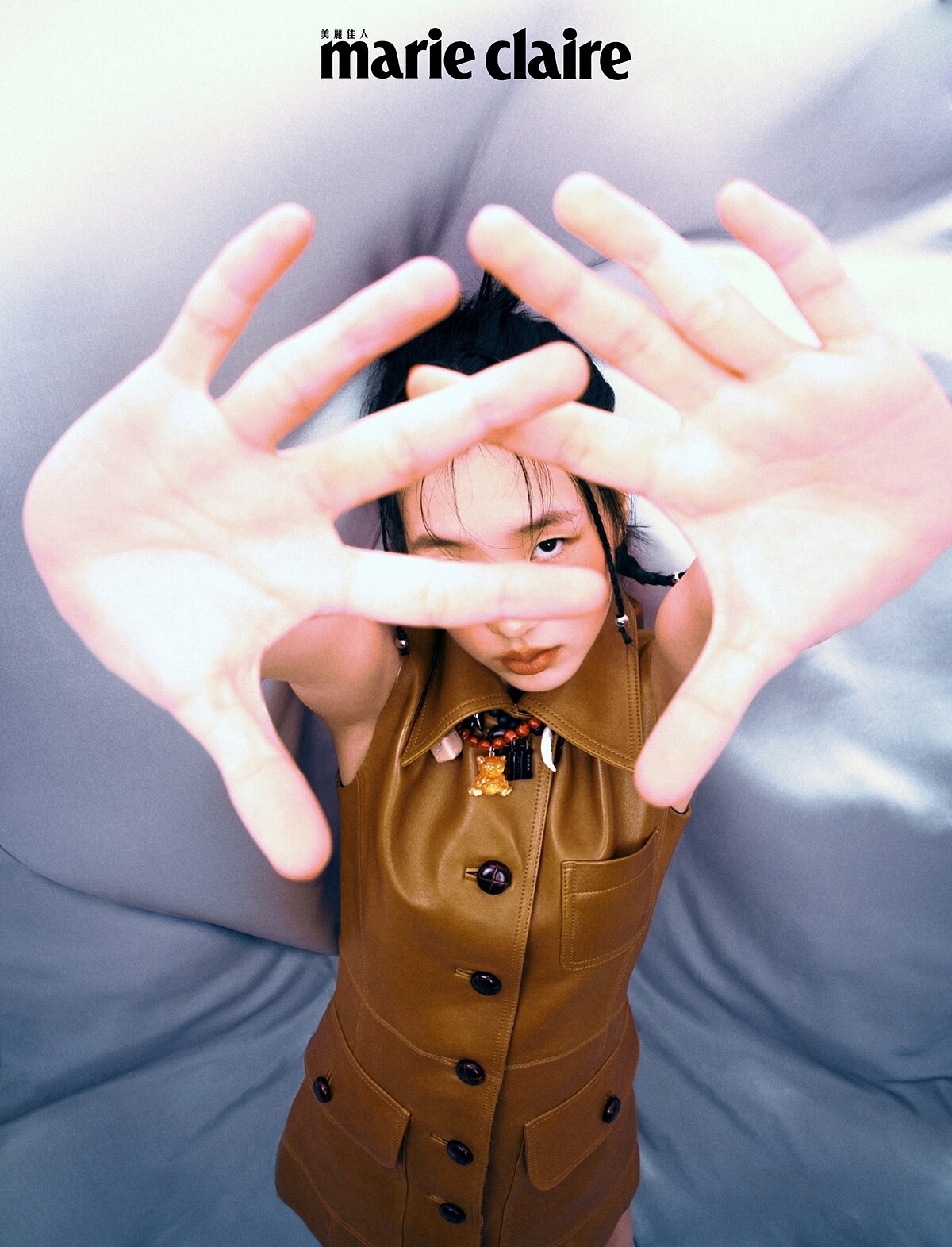 咖啡色皮革風衣背心式洋裝、泰迪熊綴飾造型項鍊、黑色鎖頭綴飾造型項鍊，all by Coach。