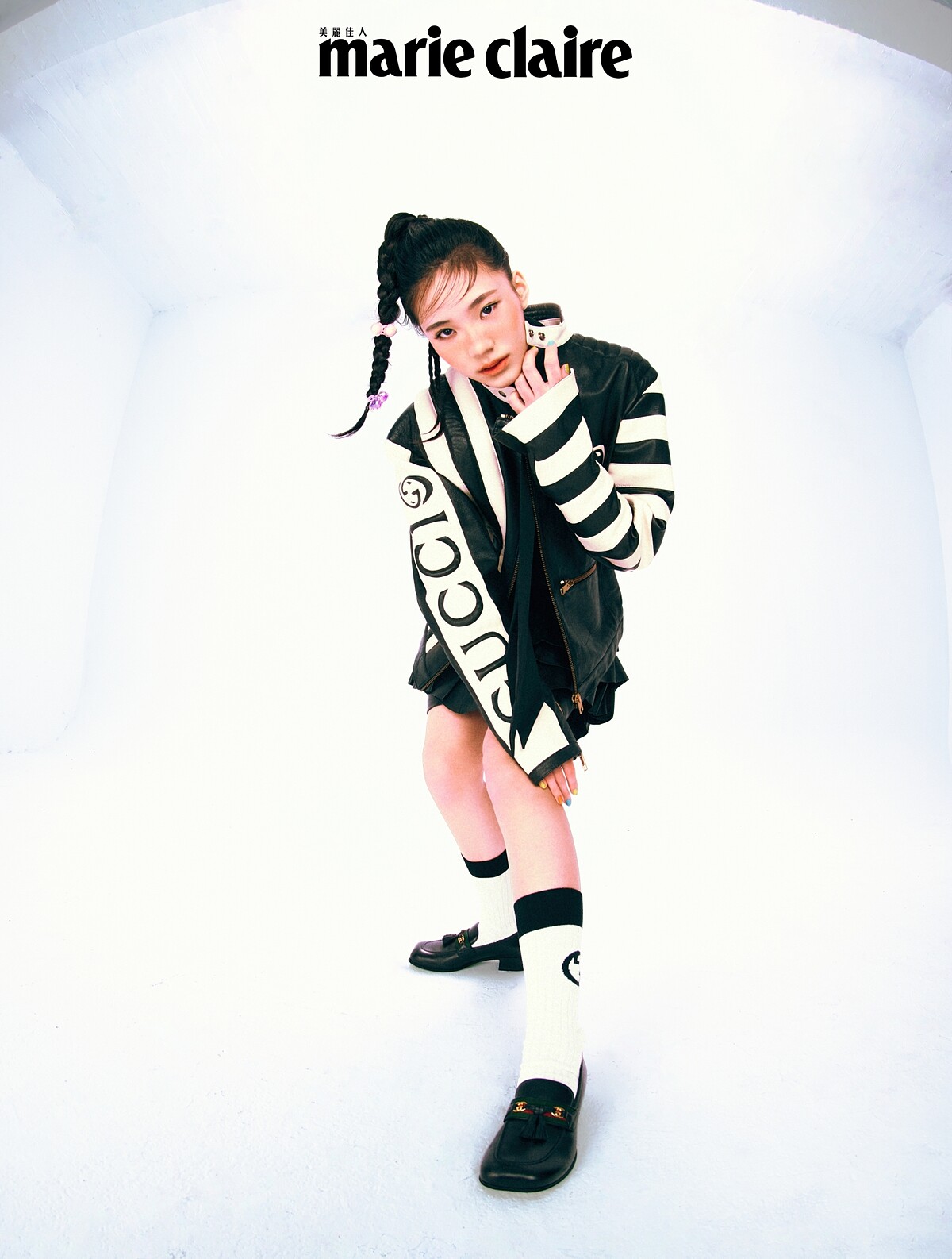 黑白色立領羊皮拉鍊夾克、黑色長袖短版襯衫、黑色法式荷葉邊短裙、白色棉襪、低跟皮鞋，all by Gucci。