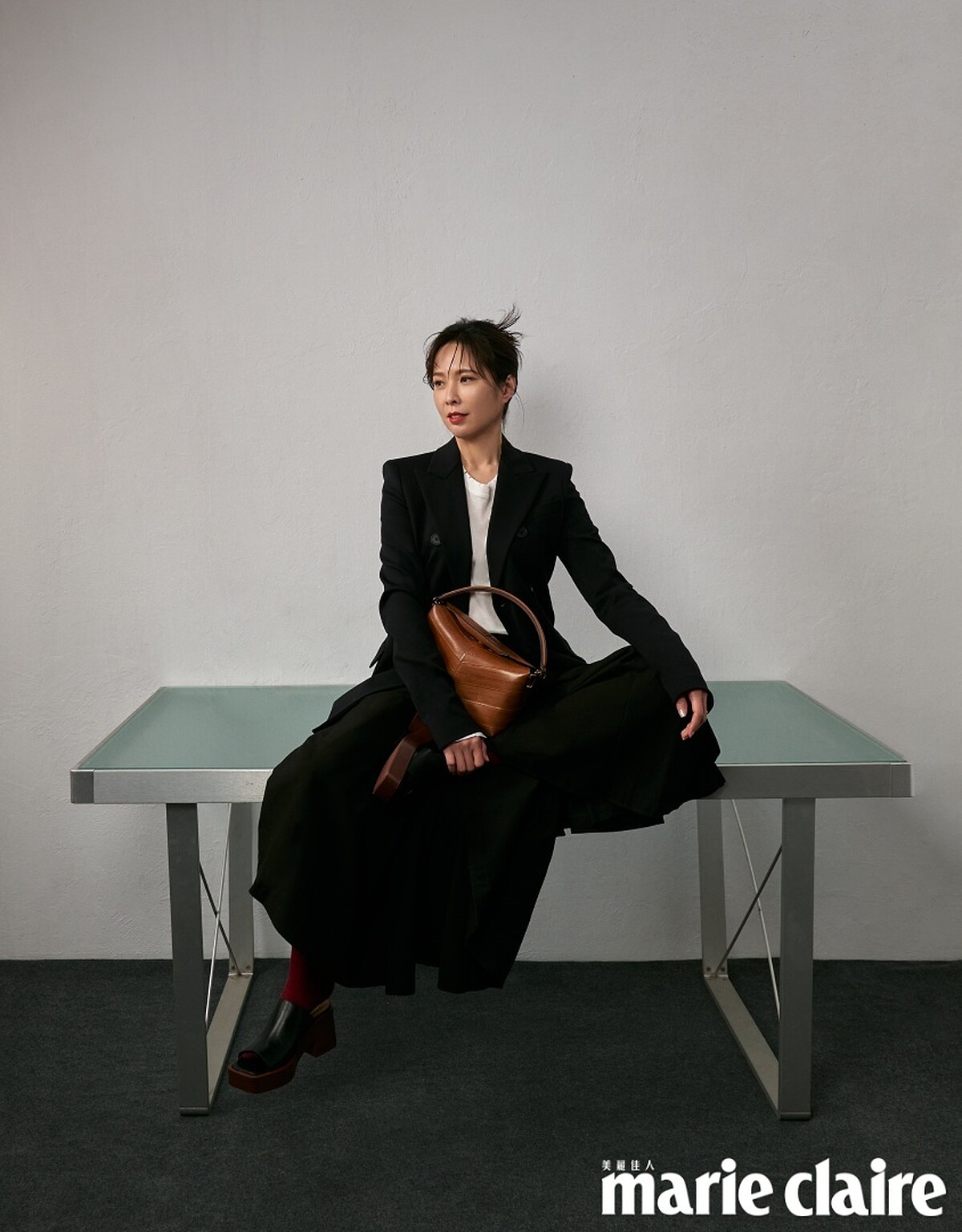 黑色西裝外套、白色 Oversize 長袖上衣、黑色圓裙，all by Sportmax；棕色皮革肩背包、黑色皮革高跟鞋，both by Tod&rsquo;s。