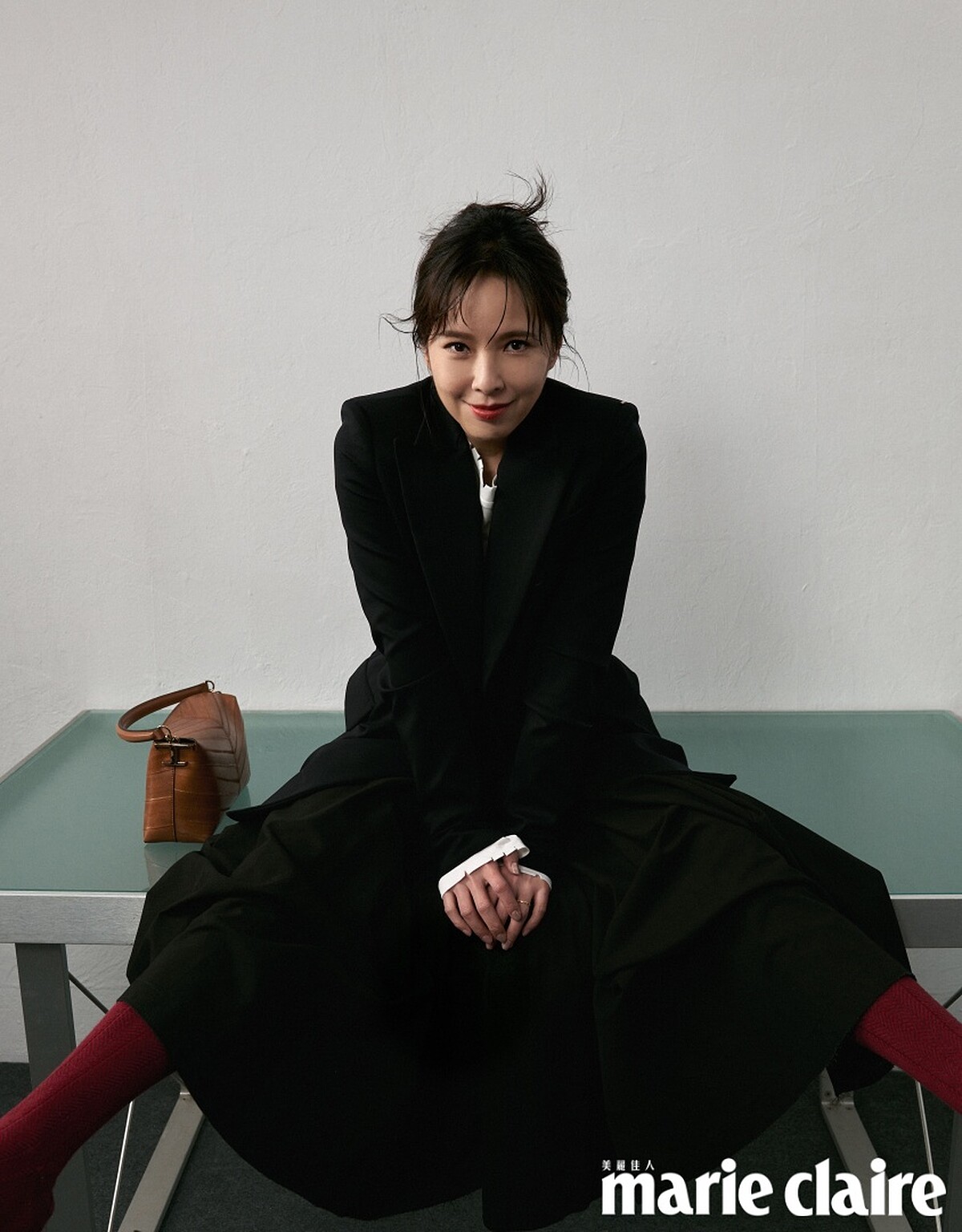 黑色西裝外套、白色 Oversize 長袖上衣、黑色圓裙，all by Sportmax；棕色皮革肩背包、黑色皮革高跟鞋，both by Tod&rsquo;s。