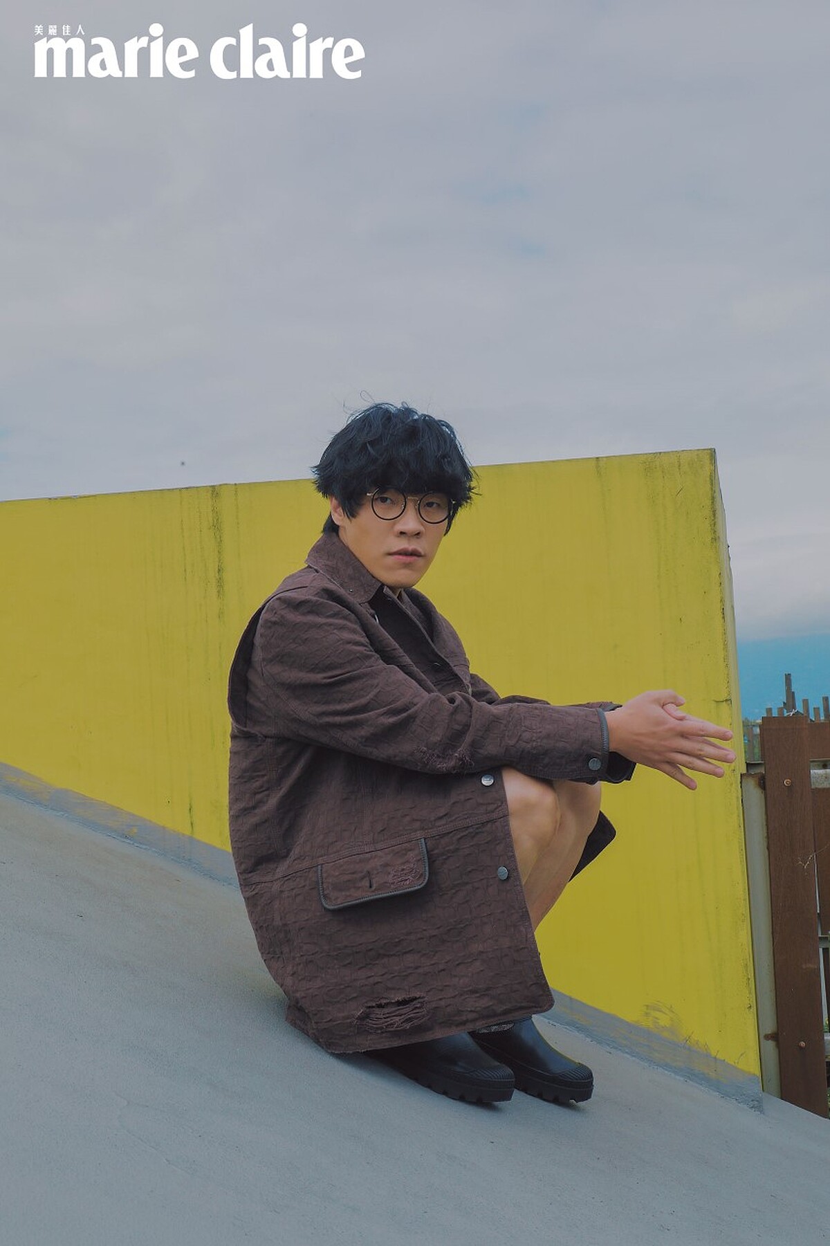 咖啡色圖紋襯衫、Oversize Parka 外套、扣飾皮革短褲、異材質拼接短靴，all by Coach。