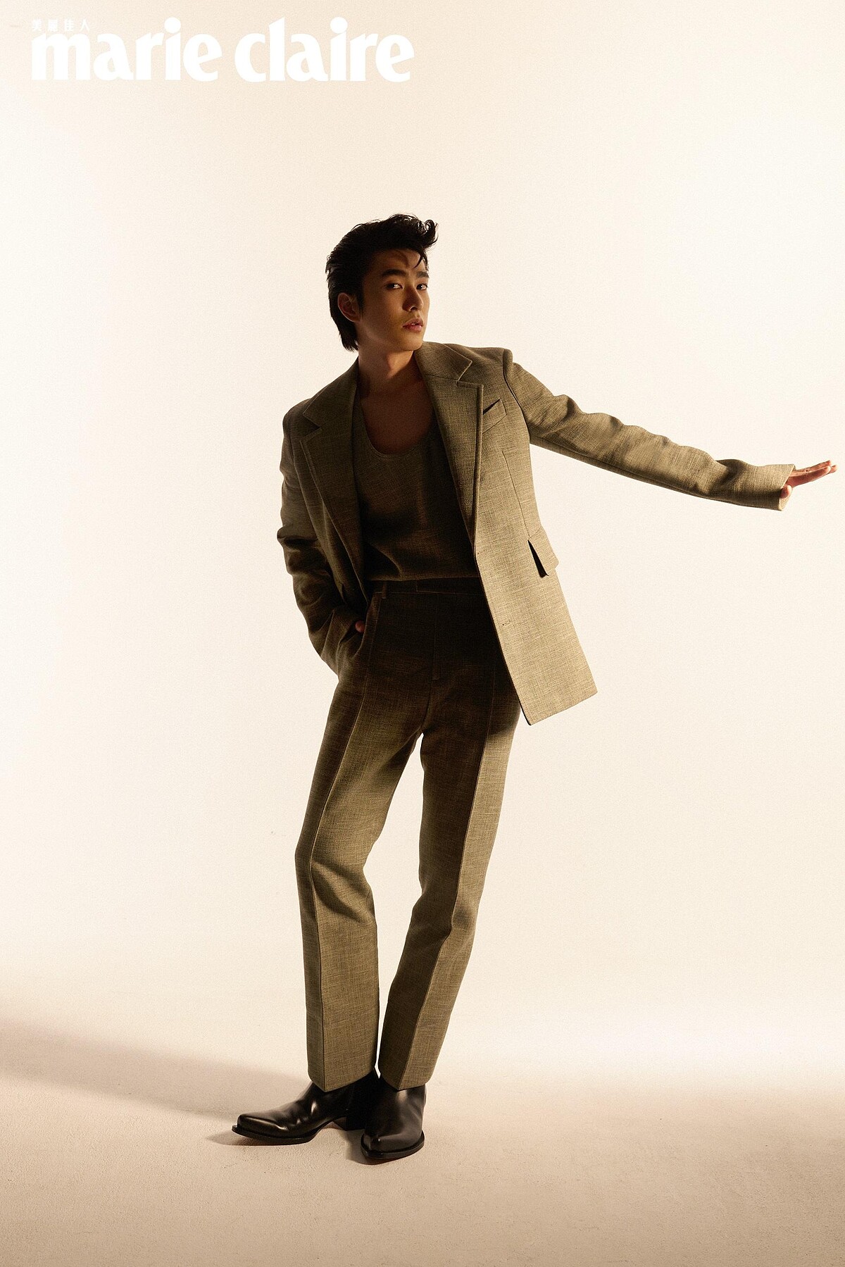 灰色西裝外套、灰色無袖上衣、灰色西裝長褲、黑色尖頭長靴，all by Bottega Veneta。