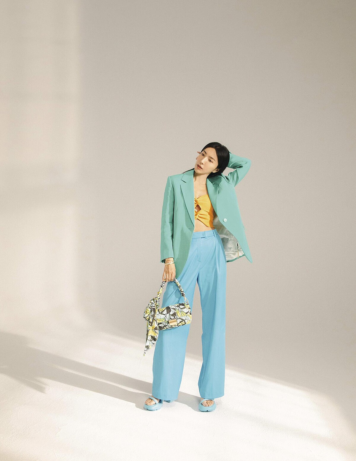 橘色針織小背心、藍綠色西裝外套，both by Sandro；水藍色西裝長褲，MAX&Co.；印花手拿包，水藍色綁帶跟鞋，both by CHARLES & KEITH；Tiffany True 戒指、Tiffany HardWear 球形戒指、Tiffany T Wire 線圈手鏈、Tiffany T1 手環、鋪鑲鑽石手環，all by Tiffany & Co.。