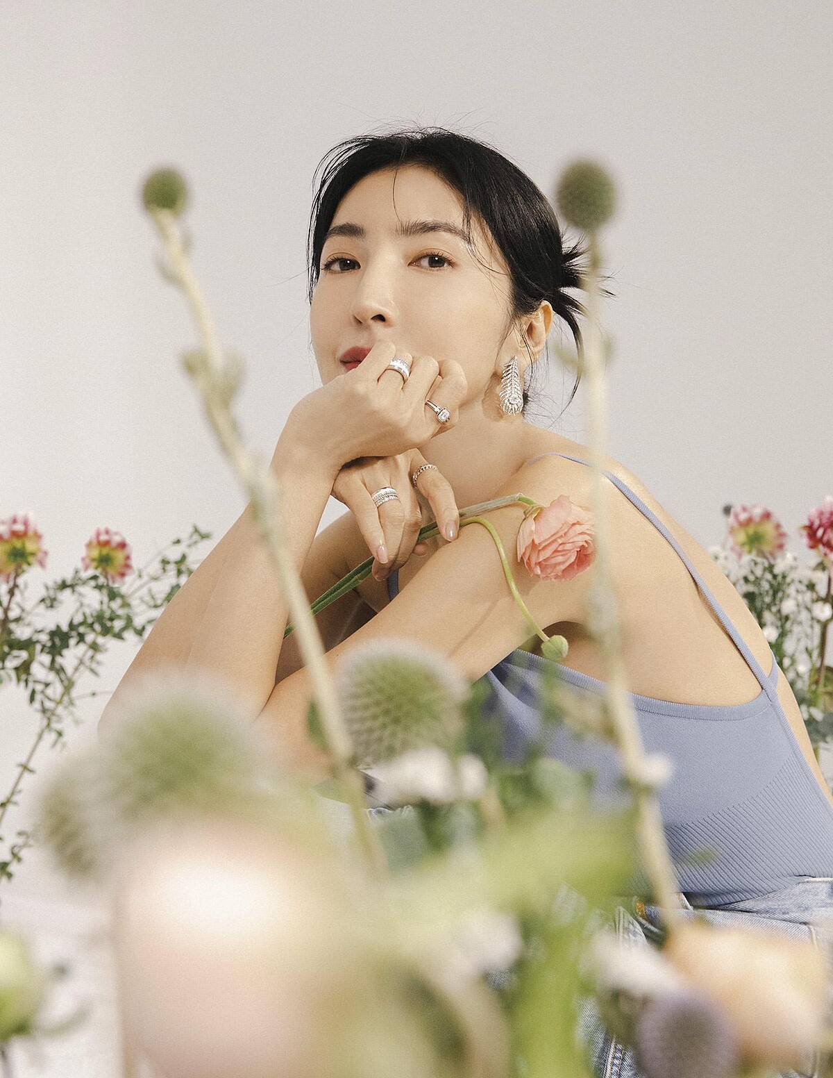 牛仔雙口袋工作褲，Sandro；水藍針織露背連身衣、水藍長大衣，both by Max Mara；Plume de Paon 鑽石耳環、Quatre戒指、Plume de Paon 戒指、Liser&eacute;戒指，all by Boucheron。