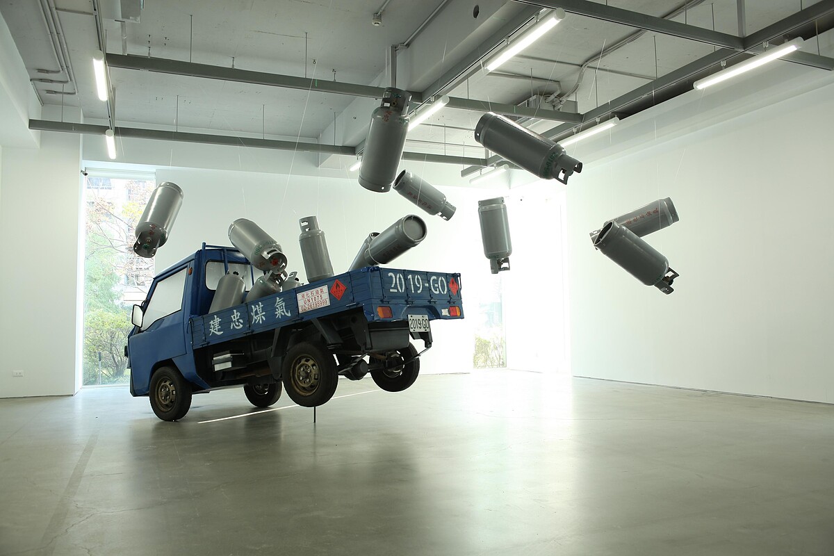 廖建忠讓沉重的瓦斯桶與小卡車如失去重力般飛躍起來，作品〈載瓦斯的小發財〉。