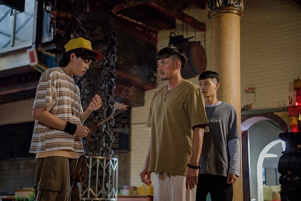 《化劫》劉子銓（左）飾演的小胖太怕阿飄向「廟公」柯叔元求救，柯教他「咬菁仔避邪」