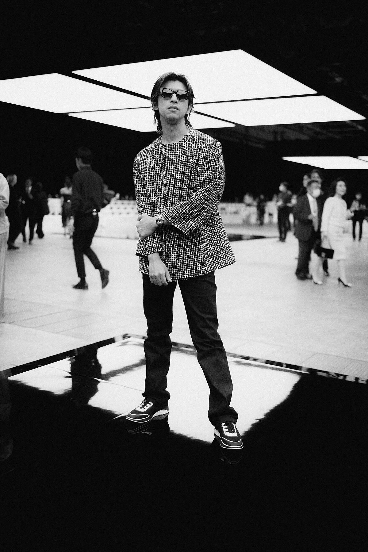 陳柏霖穿香奈兒2023/24 Cruise度假系列黑白細格紋斜紋軟呢外套、配戴香奈兒J12 黑色腕表。