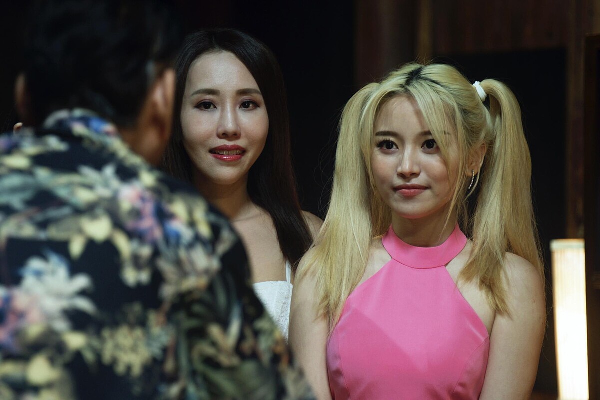 《地獄里長》蔡瑞雪（右）協助警方「臥底」假扮按摩妹，綁上小丑女的電影髮型