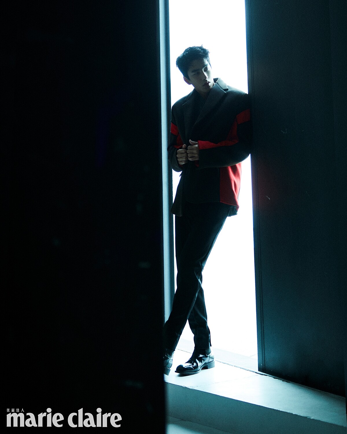 咖啡色拼接西裝外套、灰色針織衫、黑色西裝褲、黑色襪子，all by Prada；黑色皮靴，Christian Louboutin。