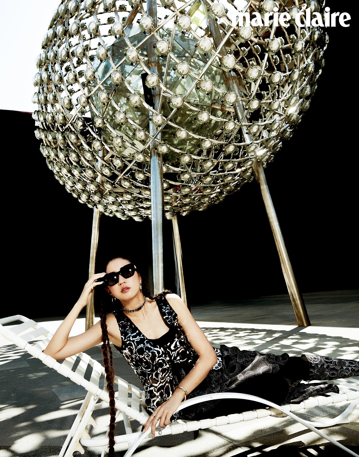 Première腕錶–原創款作頸鍊佩戴、Coco Crush 高級珠寶系列耳環、戒指多只、手鐲多只、亮片飾山茶花圖案背心、山茶花圖案長裙、圖騰高筒靴、粗框墨鏡、香奈兒1號紅色山茶花活能粉底液、香奈兒康朋街31號唇膏 #2度假,all by Chanel。