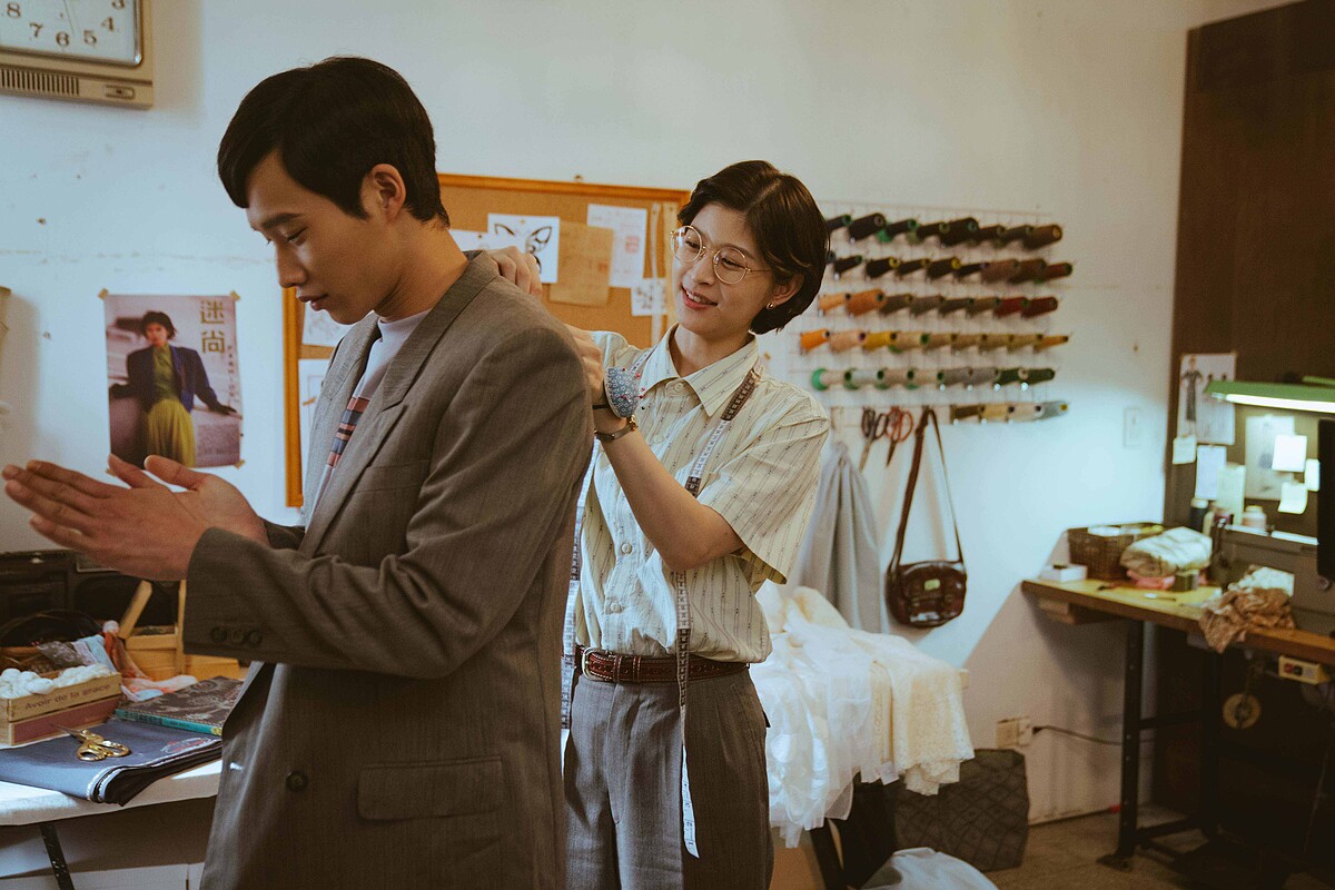 江宜蓉（右）替黃冠智量身打造結婚西裝，花絮中出現的辦桌菜「紅蟳米糕」，則是黃冠智擔心江宜蓉忙於製衣，特別做給好友的美味心意。