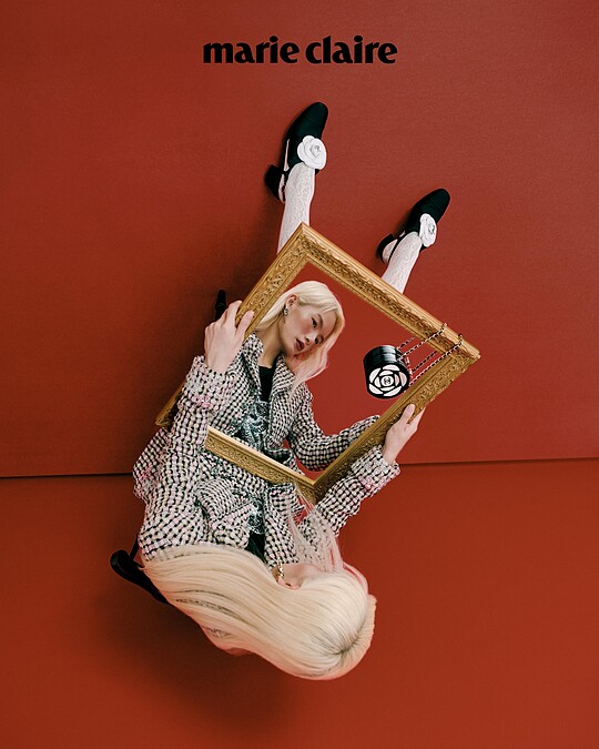 粉色斜紋軟呢格紋外套與短裙、黑色山茶花上衣、白色蕾絲絲襪、白色山茶花低跟鞋、黑白山茶花皮穿鍊小包，all by CHANEL；彩妝 ，CHANEL BEAUTY。