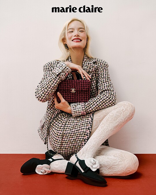 粉色斜紋軟呢格紋外套與短裙、黑色山茶花上衣、白色蕾絲絲襪、白色山茶花低跟鞋、粉色斜紋軟呢皮穿鍊手提包，all by CHANEL；彩妝 ，CHANEL BEAUTY。