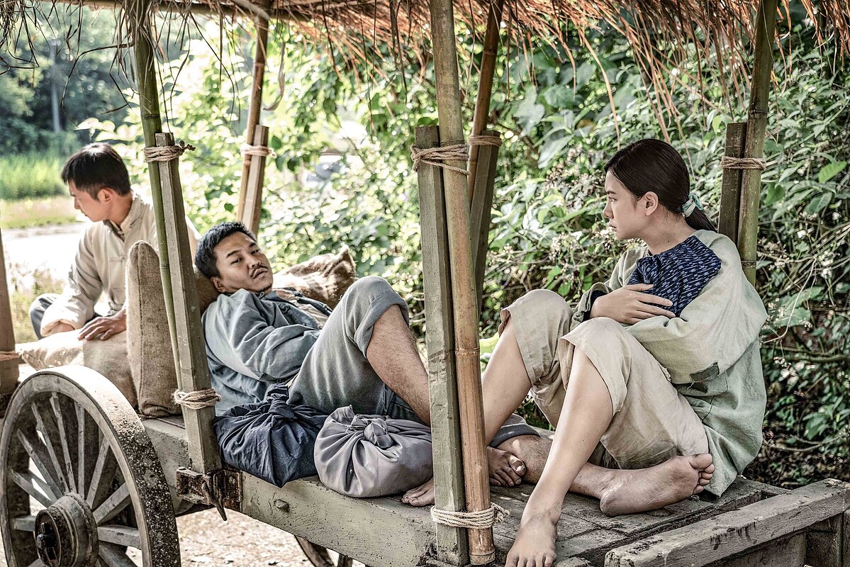 阿春(右)抱著剛出生的孩子，帶奄奄一息的丈夫日生(中)回家，但路上日生就斷氣撒手人寰