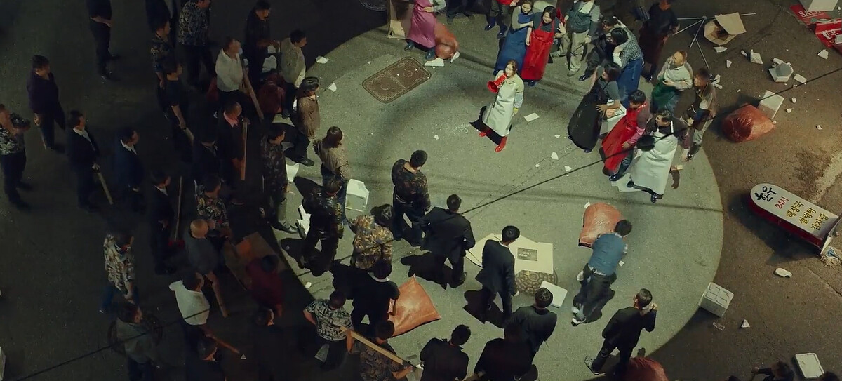 吉中干拿紅色大聲公，另一手拿菜刀與黑道叫陣，頗有《食神》雞姊氣勢