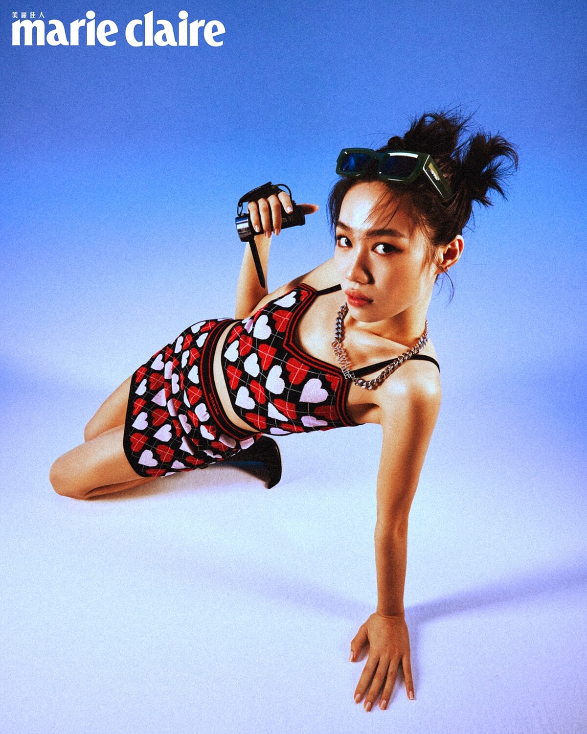 愛心印花背心、愛心印花短裙，both by MSGM；黑色金釦踝靴，Jimmy Choo；綠色窄版墨鏡、金屬項鍊，both by Off-White。