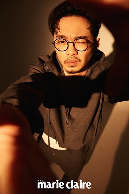 灰色連帽夾克、白色背心、灰色西裝褲，Ferragamo ；黑皮鞋，PRADA。