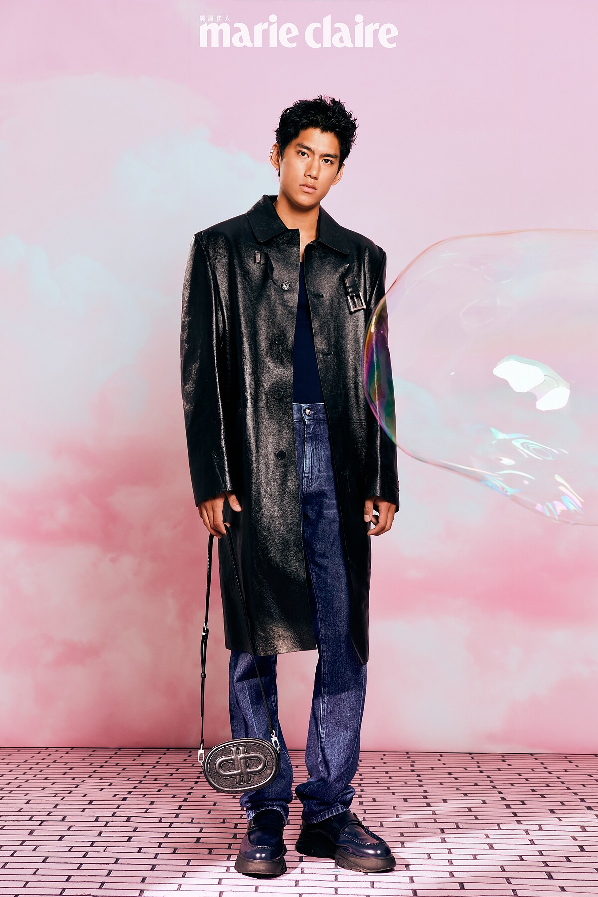 黑色皮大衣、丹寧長褲，Versace；深藍色背心，Ferragamo；Hybrix 皮革樂福鞋、PEDRO 標誌圓形皮革單肩包，both by Pedro；Quatre系列寬版戒指、Quatre系列白K耳扣、Quatre系列黃K耳扣，Boucheron。