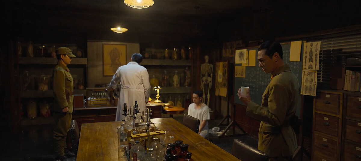 加藤中佐(右)看著空杯，問誰喝了納人？實驗醫(右二)不知誰喝的，但有四個人陸續進出實驗室，加藤的實驗魂再度燃起！