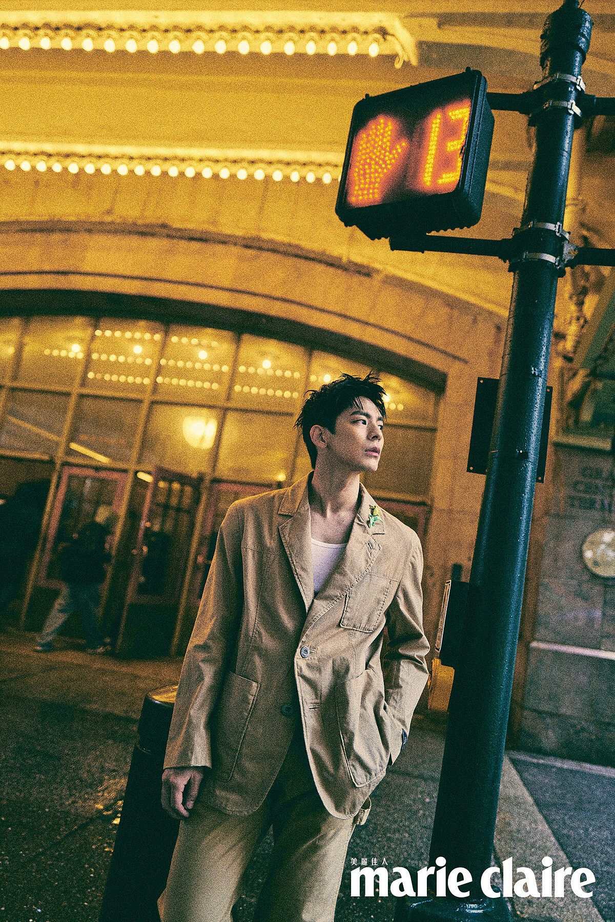 卡其色西裝外套、卡其色西裝長褲、咖啡色皮質長靴、蒼蠅恐龍不對稱胸針，all by Coach。