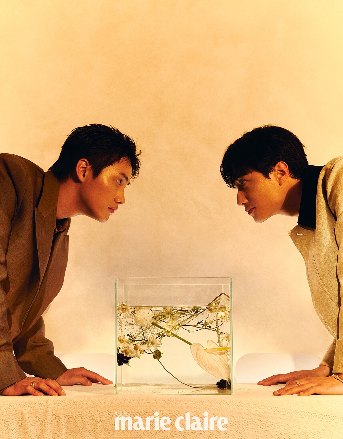 范少勳／黃褐色羊毛西裝外套、灌木叢色棉質襯衫，both by Burberry；Possession系列18K玫瑰金宮廷式雕刻飾紋手鐲、彩色藍寶石戒指、鑽石戒指，all by Piaget。劉俊謙／沙色黑領外套、灰色短袖上衣，both by Ferragamo；Possession系列18K玫瑰金宮廷式雕刻飾紋手鐲、鑽石戒指，both by Piaget。