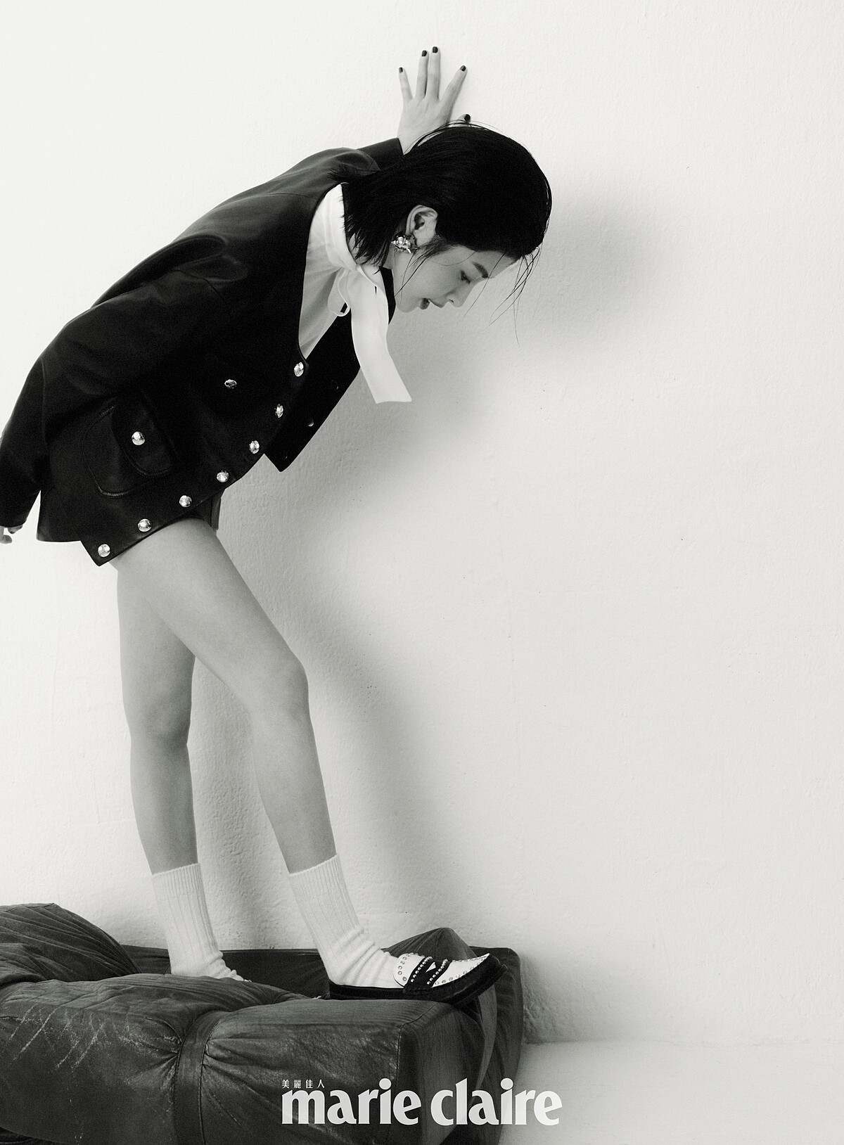 黑色柔軟羊皮革衣領外套、象牙色蝴蝶結襯衫、黑色柔軟羊皮革短裙，all by Celine by Hedi Slimane；金色造型耳環，Ferragamo；黑白色拼接鉚釘樂福鞋，Sandro。