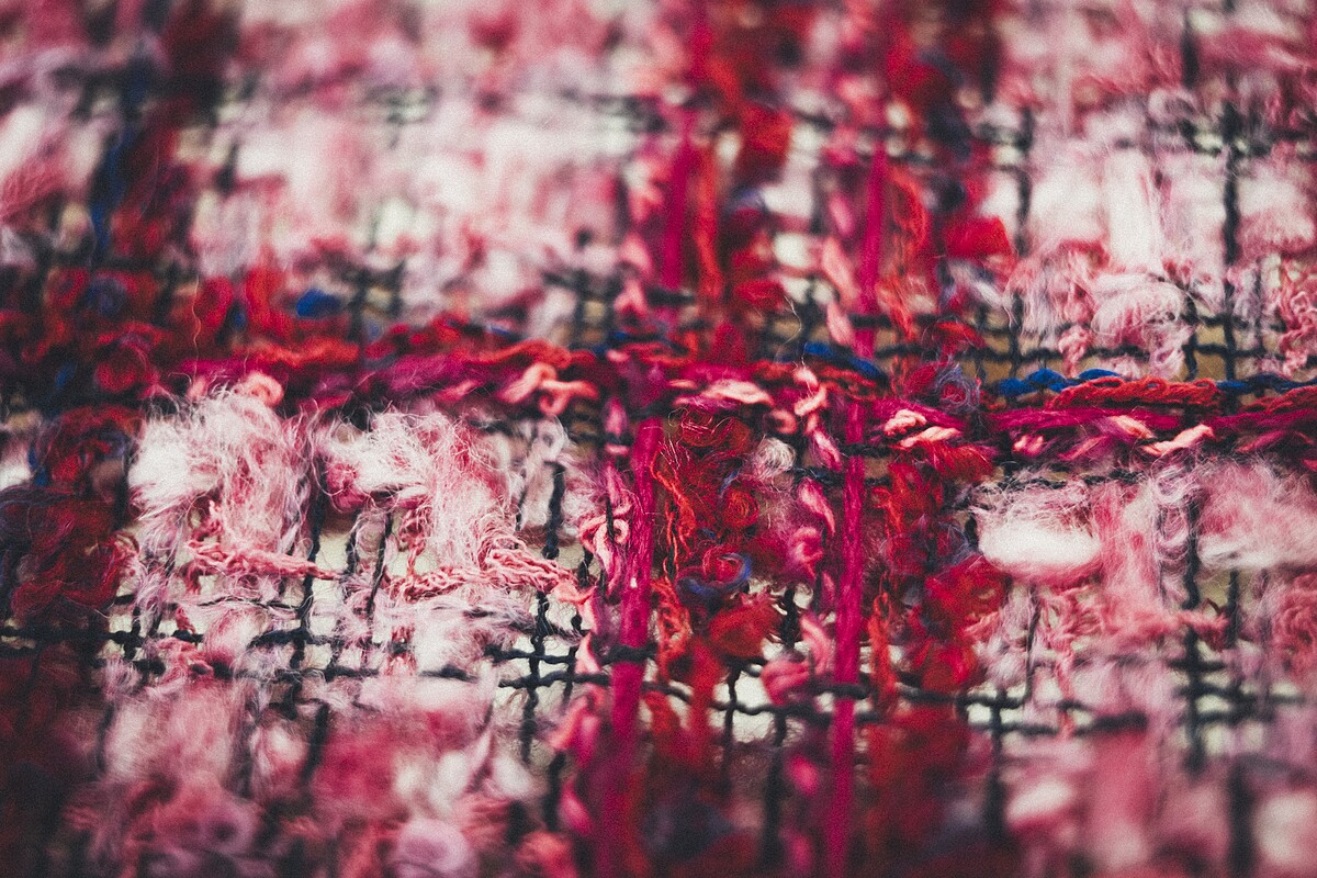 洋紅色軟呢布料細節，如同「破碎的覆盆子」，Lesage 工坊織品設計師 Anne-Lise Spivac 如此描述。