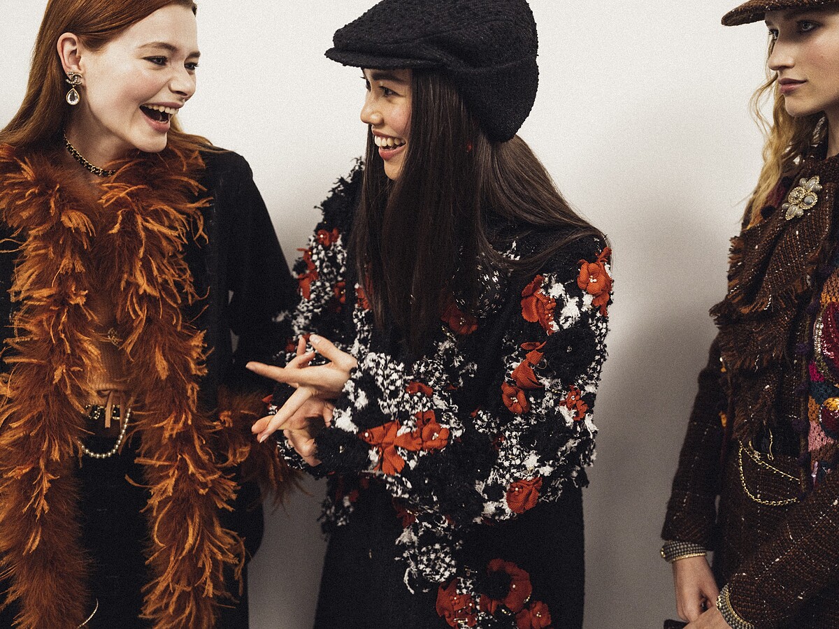 黑白斜紋軟呢外套上裝飾有磚紅色山茶花和施華洛世奇水晶（右）， Lemari&eacute; 工坊需要約一千個小時才能完成。