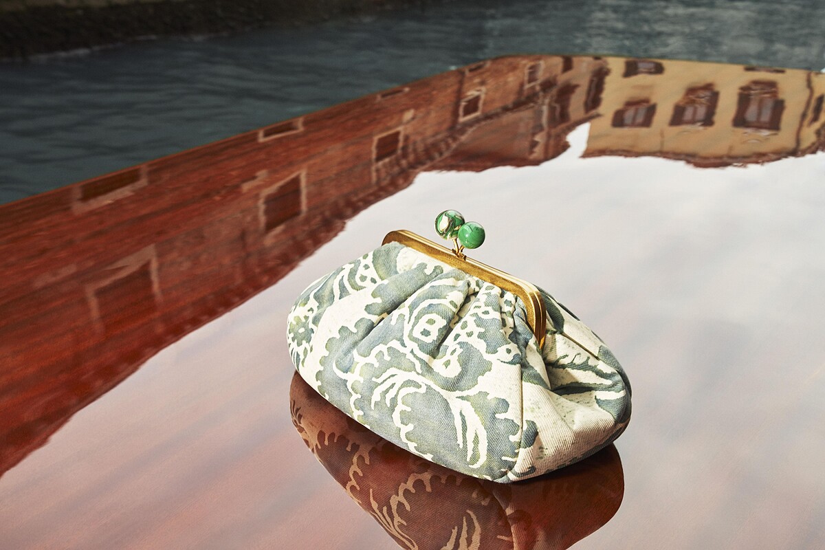 PASTICCINO點心包採用的是復古口金包的款式，甜點上兩顆可愛的櫻桃化身為放大比例、視覺明顯的圓形珠釦，甜點本身則設計為內部盛裝空間極為充裕的圓廓形。