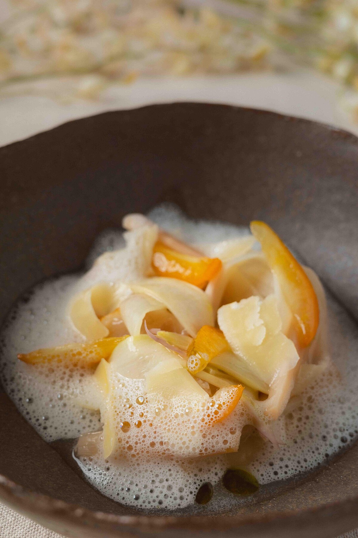 「白蘆筍、干貝、茉莉花」-新鮮的台灣白蘆筍，經過精心煎製，保留了其脆嫩的口感和自然的甜味。干貝經過高溫煎製至金黃色，外酥內嫩，釋放出濃郁的海洋鮮香，與白蘆筍的清爽形成鮮明對比，讓整道菜品在口感和風味上達到完美的平衡。發酵處理的白蘆筍帶有微酸的獨特風味，不僅增加了菜品的層次感，還為口感增添了一抹細膩的酸甜，讓人一口接一口地回味無窮。特製醬汁由茉莉花、自製甘酒和干貝高湯攪打而成，通過與空氣接觸形成細膩的泡沫。