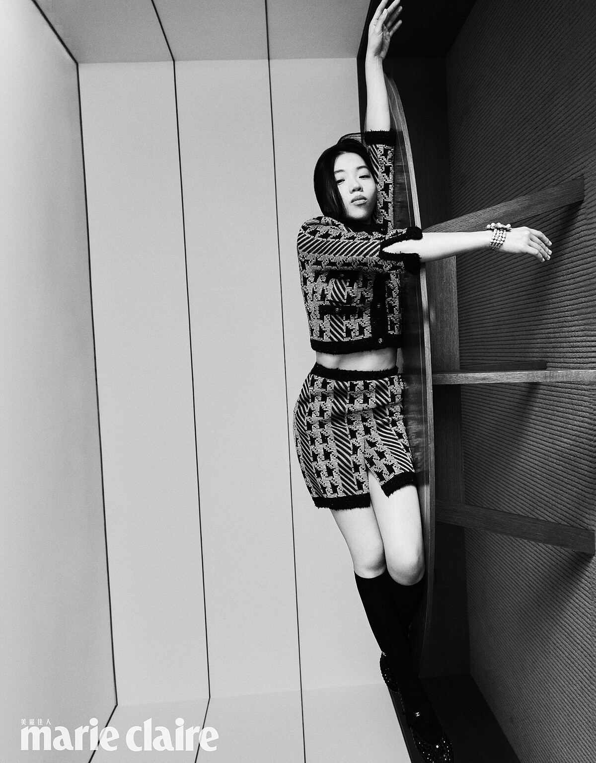 綠色千鳥格紋針織衫、綠色千鳥格紋短裙、綠色花朵手環、黑色長襪、黑色蝴蝶結瑪莉珍鞋，all by CHANEL。