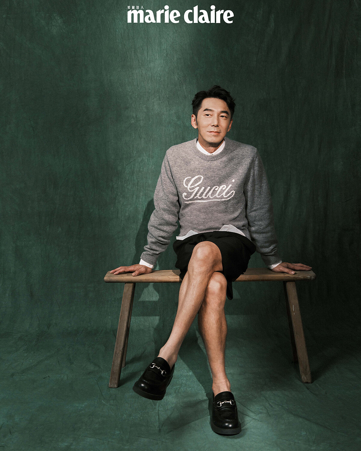 灰色毛衣、白襯衫、黑色西裝短褲、黑色皮鞋，all by Gucci。